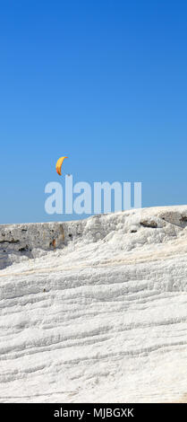 Pamukkale: parapendio volare sopra le caclium depositi dalle sorgenti termali naturali. Foto Stock