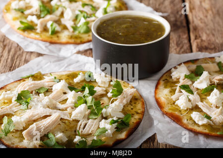 Mexican street food: chalupas piccante con il formaggio e la carne di pollo con la salsa di close-up sul tavolo orizzontale. Foto Stock