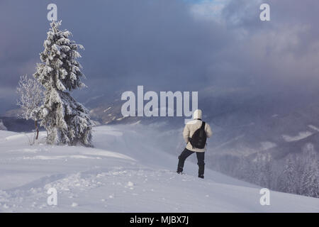 Escursioni con le racchette da neve walker in esecuzione in polvere di neve con bellissima alba luce. Outdoor attività invernali e uno stile di vita sano. Foto Stock