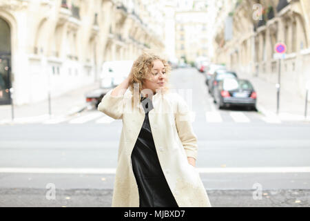 Insegnante bionda passeggiate in città e in piedi in background su strada. Foto Stock