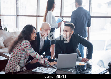 Giovane team di collaboratori di grande discussione aziendale nel moderno ufficio coworking. Il lavoro di squadra di persone concetto. Foto Stock