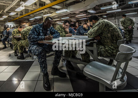 180502-N-CL027-0005 Yokosuka, Giappone (maggio 02, 2018) marinai prendere la marina militare tardo-ampio esame di avanzamento in avanti il disordine dei ponti a bordo della marina distribuita portaerei USS Ronald Reagan (CVN 76). Ronald Reagan, il portabandiera del Carrier Strike gruppo 5, fornisce un combattimento-pronto forza che protegge e difende la collettiva degli interessi marittimi dei suoi alleati e partner in Indo-Asia-regione del Pacifico. (U.S. Foto di Marina di Massa lo specialista di comunicazione 2a classe Janweb B. Lagazo) Foto Stock