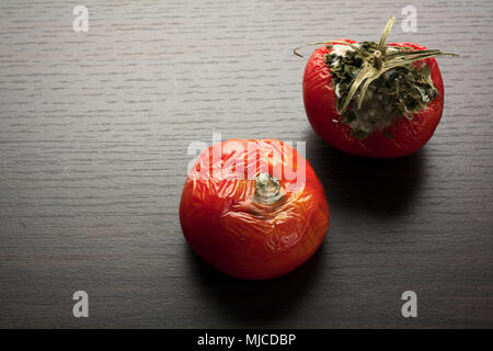 Pomodori marci su sfondo di legno Foto Stock