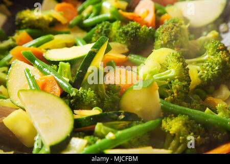 La cucina wok con verdure, carote, zucchine, pole fagioli, broccoli, latte fresco e sano Foto Stock