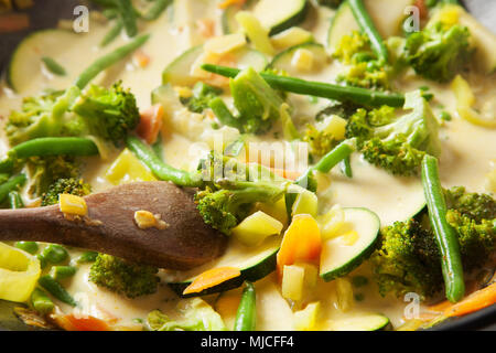 La cucina wok con verdure, carote, zucchine, pole fagioli, broccoli, latte fresco e sano Foto Stock