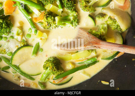 La cucina wok con verdure, carote, zucchine, pole fagioli, broccoli, latte fresco e sano Foto Stock