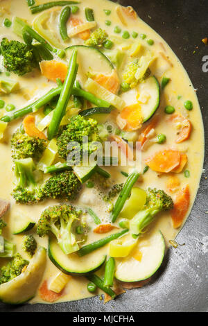 La cucina wok con verdure, carote, zucchine, pole fagioli, broccoli, latte fresco e sano Foto Stock