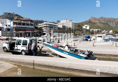 Port de Pollenca, Mallorca, Spagna. 2018. L'uomo winching una barca dalla marina in questa cittadina di mare di Porto Pollenca Maiorca. Foto Stock