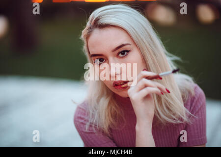 Giovane ragazza piuttosto pittore tracciare nel parco. Close up ritratto con spazzole. Foto Stock