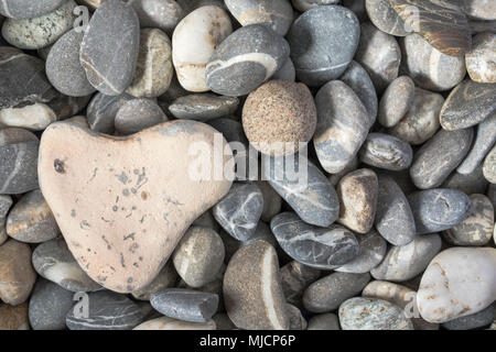 Di pietra a forma di cuore sulla spiaggia ghiaiosa Foto Stock