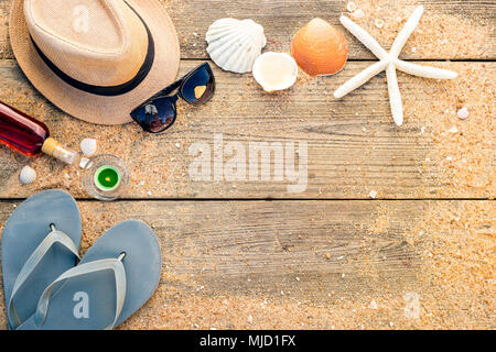 Estate accessori come hat, conchiglie e occhiali da sole in legno e lo sfondo di sabbia Foto Stock