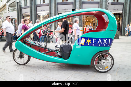 Vienna Austria il 3 maggio. 2018, Faxi è un'Austria risciò bicicletta taxi company, conducente spingendo il veicolo in strada piena di turisti Foto Stock