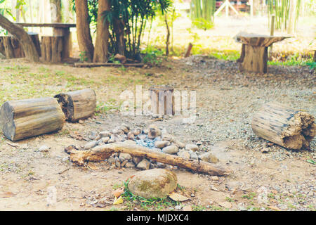 Le panche di legno intorno alla pietra e roccia una buca per il fuoco. Foto Stock