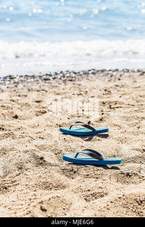 Blue flip-flop sulla spiaggia Foto Stock