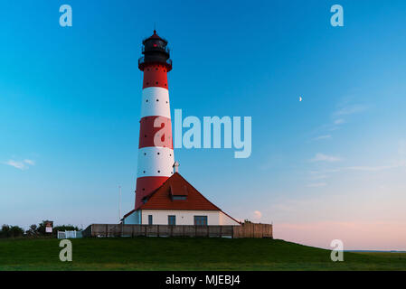 Faro Westerheversand con luna nell'ultima luce della sera Foto Stock