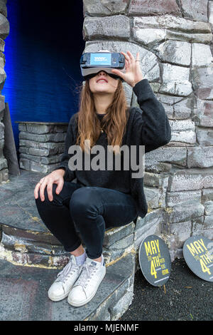 Donna che indossa la realtà virtuale auricolare per visualizzare le Skellig Rocks, nella contea di Kerry, Irlanda dall' isola Valentia Visitor Center, organizza per Failte Ireland Tourism, durante il mese di maggio la quarta banca weekend di vacanza Foto Stock