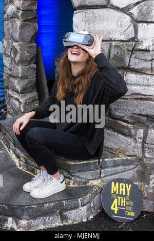 Donna che indossa la realtà virtuale auricolare per visualizzare le Skellig Rocks, nella contea di Kerry, Irlanda dall' isola Valentia Visitor Center, organizza per Failte Ireland Tourism, durante il mese di maggio la quarta banca weekend di vacanza Foto Stock