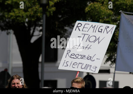 Kandel, Germania. Il 5 maggio 2018. Un diritto-wing manifestanti porta un cartello che recita "Remigration anziché alla risocializzazione'. Circa 300 persone da destra-wing le organizzazioni hanno protestato nella città di Kandel nel Palatinato contro i rifugiati e gli stranieri e il governo tedesco. Il luogo della protesta è stato scelto a causa del 2017 Kandel accoltellato l'attacco, in cui un 15 anno vecchia ragazza è stata uccisa da un richiedente asilo. Essi sono stati affollata da circa 200 anti-fascista contro i dimostranti da differenti polit Credito: Michael Debets/Alamy Live News Foto Stock