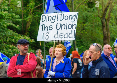 Glasgow, Scotland, Regno Unito. Il 5 maggio, 2018. Migliaia di attivisti a sostegno dell indipendenza scozzese marzo attraverso le strade di Glasgow. Organizzata dal gruppo Tutti sotto uno striscione del marzo percorsa da Kelvingrove Park attraverso la città di Glasgow Green. Foto di un uomo che indossa una maschera dell'ex leader del Partito conservatore del Regno Unito e il primo ministro Margaret Thatcher che trasportano un banner che dice Ding Dong l'Unione è morta. Credito: Berretto Alamy/Live News Foto Stock