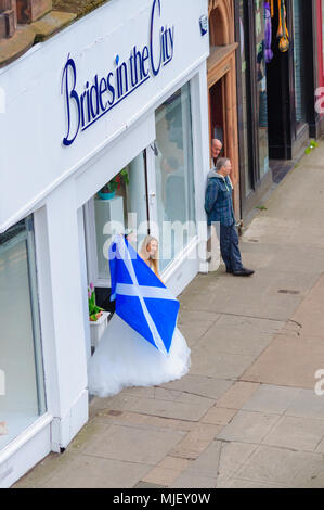 Glasgow, Scotland, Regno Unito. Il 5 maggio, 2018. Migliaia di attivisti a sostegno dell indipendenza scozzese marzo attraverso le strade di Glasgow. Organizzata dal gruppo Tutti sotto uno striscione del marzo percorsa da Kelvingrove Park attraverso la città di Glasgow Green. Foto di una giovane donna che indossa un abito da sposa esce di spose in città portando una bandiera scozzese e cheers sui dimostranti. Credito: Berretto Alamy/Live News Foto Stock