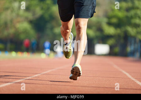 Giovane uomo asiatico atleta maschio esegue la formazione esercita sulla via. Foto Stock