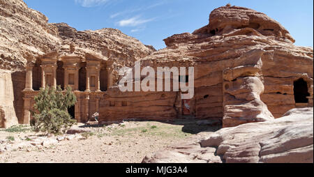 Grotta abitazione, che è ancora oggi utilizzato come camera di stoccaggio e nella sala di ricreazione con Monastero Al-Deir in background nelle montagne di Petra, Jo Foto Stock