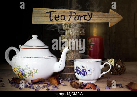 Tea Party. Tazza di tè e teiera sul tavolo di legno con segno di freccia in background Foto Stock