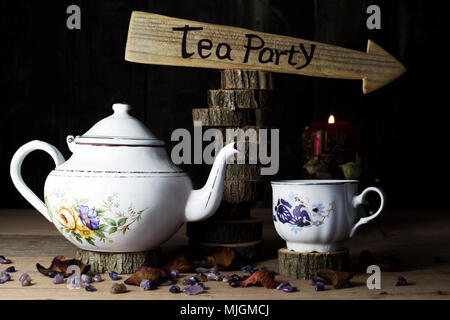 Tea Party. Tazza di tè e teiera sul tavolo di legno con segno di freccia in background Foto Stock