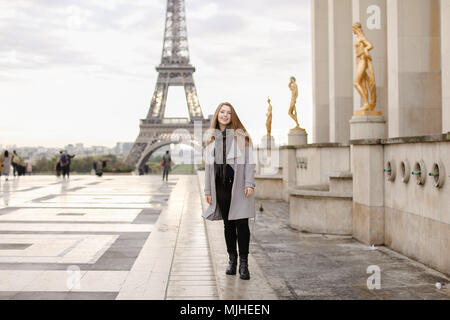 Pretty Woman Standing sulla piazza del Trocadero vicino a statue dorate e la Torre Eiffel. Foto Stock