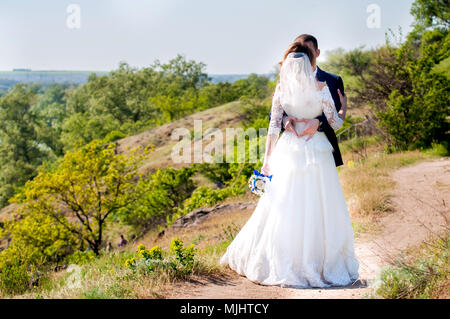 Gli ospiti gettando coriandoli sopra la sposa e lo Sposo ad un matrimonio civile, indiana, figlia Foto Stock