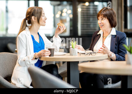 Le donne d'affari durante un tempo di caffè nella caffetteria Foto Stock