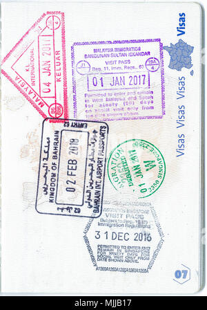 Francobolli della Malesia e Bahrain e Singapore in un passaporto francese. Dati personali rimosso Foto Stock