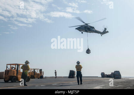 171201-N-ZS023-028 GOLFO ARABICO (dec. n. 1, 2017) un MH-60S Sea Hawk assegnato al "Jolly" di elicottero di mare squadrone di combattimento (HSC) 23 a bordo dell'assalto anfibio nave USS America (LHA 6) distribuisce il carico sul ponte di volo durante un rifornimento in mare. L'America è l'ammiraglia per l'America anfibio gruppo pronto e, con l'avviato xv Marine Expeditionary Unit, è distribuito negli Stati Uniti Quinta Flotta area di operazioni a sostegno della sicurezza marittima operazioni destinate a rassicurare gli alleati e partner e preservare la libertà di navigazione e il libero flusso di commercio nella regione. (U.S Foto Stock