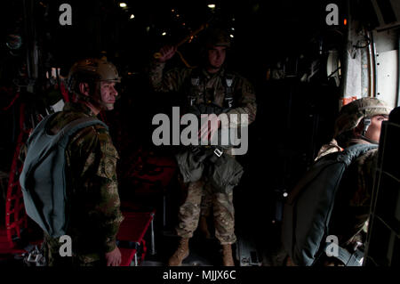 Il personale Sgt. Stephen West, Un jumpmaster con la XVIII Airborne Corp, centro si prepara a paracadute un C-130 come Stati Uniti e Columbian jumpmasters assicurare che è sicuro per uscire il piano durante la lotteria del salto del funzionamento del giocattolo di scendere a Fort Bragg, N.C., Dicembre 2, 2017. Il funzionamento del giocattolo Drop è la più grande del mondo di combinata airborne funzionamento e formazione collettiva esercizio con sette partner-nazione paracadutisti che hanno partecipato e soldati consentito l'opportunità di aiutare i bambini nel bisogno di ricevere giocattoli per le vacanze. (U.S. Foto dell'esercito da Staff Sgt. Michael T. Crawford) Foto Stock