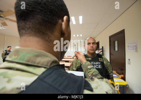 Stati Uniti Il personale dell'esercito Sgt. Sergio Lopez, assegnato all'Schinnen Provost Marshall ufficio presso U.S. Army Garrison Benelux, segue la penna DETENUTE DAGLI STATI UNITI Army Sgt. Chase Sykes, come Sykes esegue un sguardo orizzontale nistagmo durante il test di campo standard sobrietà di prova sulla formazione Wingene Air Base, Belgio, Dicembre 5, 2017. I soldati praticato eseguendo il Campo prove di sobrietà per ricevere l'applicazione della legge di certificazione. (U.S. Esercito foto di Visual Information Specialist Pierre-Etienne Courtejoie) Foto Stock