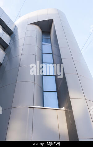 Close-up parte di un edificio moderno con una facciata liscia. Basso angolo di ripresa. Foto Stock