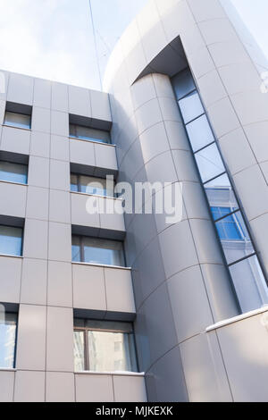 Close-up parte del grigio chiaro edificio moderno con finestre di vetro. Foto Stock