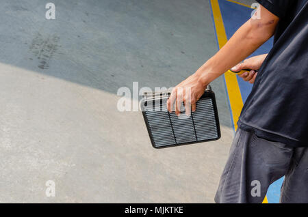 Gli uomini stanno utilizzando la soffiante per pulire il filtro dell'aria auto. Foto Stock