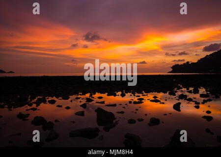 La luminosità del tramonto sul cielo, riflessione dalla linea di bassa marea beach. Colorato tramonto cielo con la luminosità del tramonto. Foto Stock