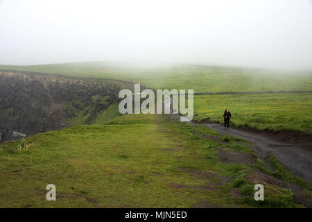 Le donne in esecuzione da scogliere di Moher in Irlanda Foto Stock