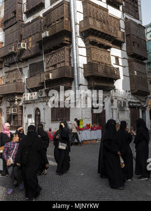 Donne saudite camminando per le strade di Al Balad, la sezione storica di Jeddah, Arabia Saudita vestita di nero abayas Foto Stock