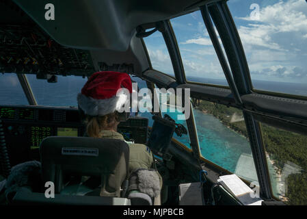 Stati Uniti Air Force Capt. Cerre Dolby, C-130J Super Hercules comandante con la trentaseiesima Airlift Squadron, guarda alla costa di seguito durante un a basso costo e bassa altitudine airdrop durante il funzionamento caduta di Natale 15 dicembre 2017, sopra Murilo atollo. Ogni dicembre, C-130 personale di volo da Yokota Air Base testa a Andersen AFB. Da lì, sono in grado di offrire cibo donato, forniture di materiali didattici e giocattoli per remote isole del Pacifico in tutto il Commonwealth delle Marianne settentrionali, Stati Federati di Micronesia e Repubblica di Palau. Queste isole sono alcuni dei luoghi più remoti del globo spa Foto Stock