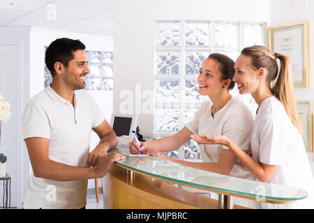 Sorridente uomo europeo parlando con i giovani infermieri in ambulatorio medico Foto Stock