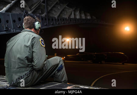 Il personale Sgt. Kyle Herzog, XIV Airlift Squadron C-17 Globemaster III loadmaster, guida i piloti mentre invertendo l'aereo sulla pista di rullaggio prima simulato un giunto di ingresso forzato missione a base comune, Charleston S.C., il 9 dicembre 2017. Più di 40 aerei hanno partecipato a questa porzione di mobilità di U.S. Air Force armi di integrazione scolastica in corrispondenza di un intervallo di prova vicino alla Nellis Air Force Base, Nev., dove la mobilità avieri vengono insegnate le competenze avanzate per condurre JFE missioni nella ben difeso aree. (U.S. Air Force photo by Staff Sgt. Trevor T. McBride) Foto Stock