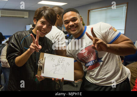 Gli ICM FUTENMA, Okinawa, in Giappone- Nozomu Miyagi, sinistra, e Lance Cpl. Malik Miller posano con il loro disegno dopo una partita a Pictionary nel singolo programma marino edificio dic. 17 su Marine Corps Air Station Futenma, Okinawa, in Giappone. Questa è stata la prima volta Kokusai gli studenti universitari hanno partecipato ad un evento sulla base. I giocatori utilizzati inglese e giapponese parole, contando su un partner per aiutarli con le parole. Questi eventi creano un divertente e ambiente rilassato, consentendo ai partecipanti di raggiungere e creare nuove amicizie. Miyagi è uno studente al Kokusai università. Miller è una tattica di difesa dell'aria condizionata Foto Stock