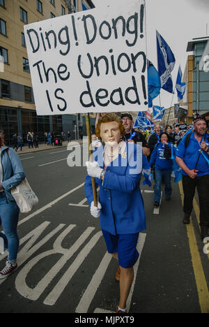 Glasgow, Glasgow City, Regno Unito. Il 5 maggio, 2018. Un uomo vestito da ex-UK PM Margaret Thatcher è visto indossare un blu business suit e una maschera del suo viso detiene una lettura del segno "ING! DONG! L'Unione europea è morta!'' durante la protesta.Migliaia di indipendenza scozzese sostenitori hanno marciato attraverso Glasgow come parte della ''˜tutti sotto uno striscione di protesta, come la coalizione si propone di eseguire tale evento fino a che la Scozia è ''˜liberi Credito: Stewart Kirby SOPA/images/ZUMA filo/Alamy Live News Foto Stock