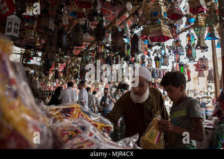 Il Cairo, Egitto. 05 Maggio, 2018. Un uomo anziano ispeziona tradizionali lanterne di Ramadan 'Fanous' sul display per la vendita in un mercato di strada, davanti al santo il mese di digiuno del Ramadan, al Cairo, Egitto, 05 maggio 2018. Il Ramadan è il nono e più sacro mese del calendario islamico in cui i musulmani di tutto il mondo di astenersi dal mangiare, bere e fumare dall alba al tramonto. Credito: Gehad Hamdy/dpa/Alamy Live News Foto Stock