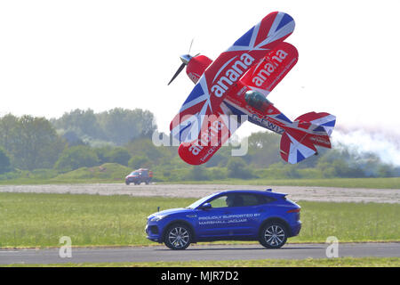 Oxfordshire, Regno Unito, 6 maggio 2018. Il pilota temerario Richard Goodwin ha volato il suo Pitts biplano speciale a fianco di una Jaguar F-ritmo lungo la pista a Abingdon. Questa è stata la prima volta in questa esibizione è stata mostrata nel Regno Unito. Foto Stock