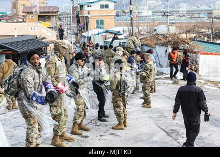 I partecipanti si alzano in una linea e consegnare bricchette di carbone al partecipante successivo in Dongducheon, Repubblica di Corea, Dic 20, 2017. Il caso è stato quello di rafforzare il rapporto tra l esercito e le comunità locali fornendo fonti di calore per i bisognosi residenti per il loro soggiorno attraverso l'inverno. (U.S. Esercito foto di PFC. Keonhee Lee, 210th FA BDE PAO) Foto Stock