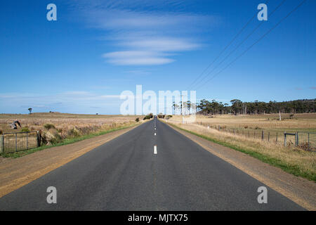 Strada aperta sulla Tasman Autostrada in direzione nord sulla costa Est della Tasmania con il cielo limpido. Foto Stock